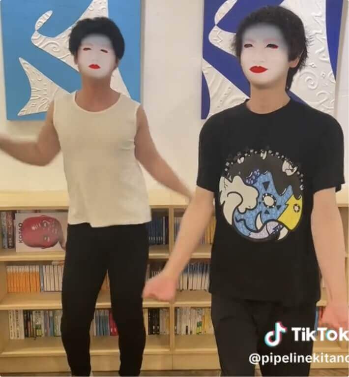 画像:2人の男性が顔に舞子さんのように白塗りを設定している様子